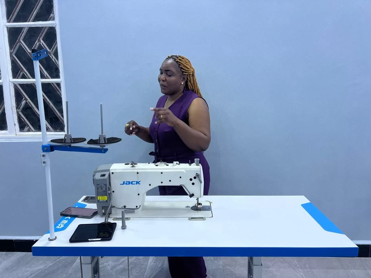 Formatrice devant une machine à coudre industrielle installée sur table professionnelle